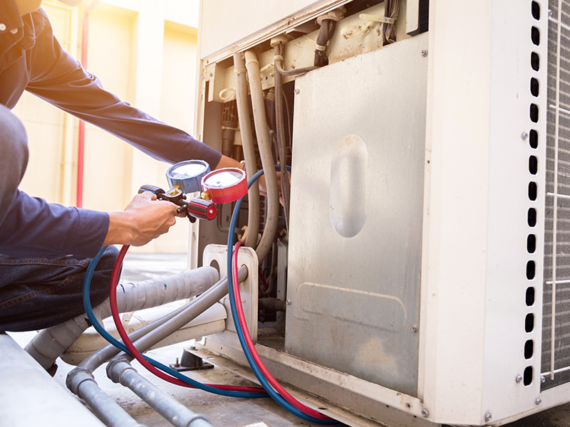 hvac technician repairing air conditioner unit at commercial property collinsville il