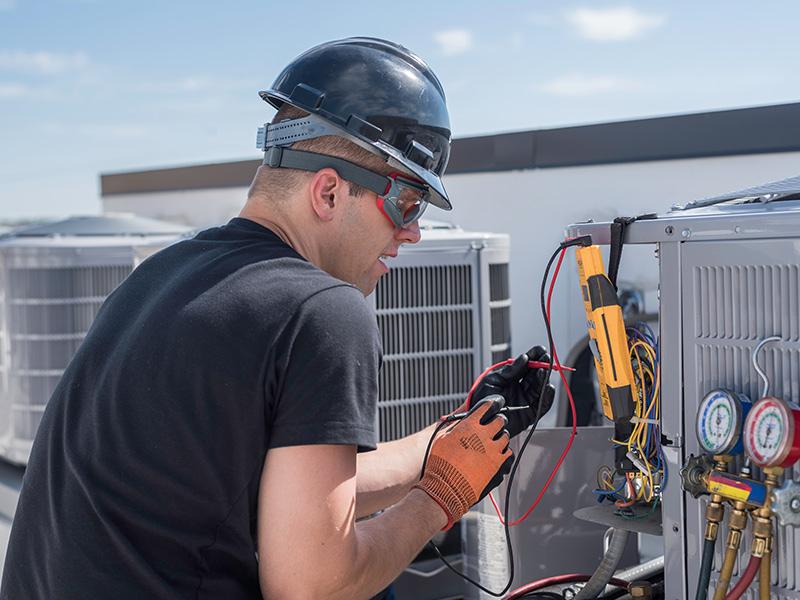 hvac technician repairing commercial building air conditioner units collinsville il