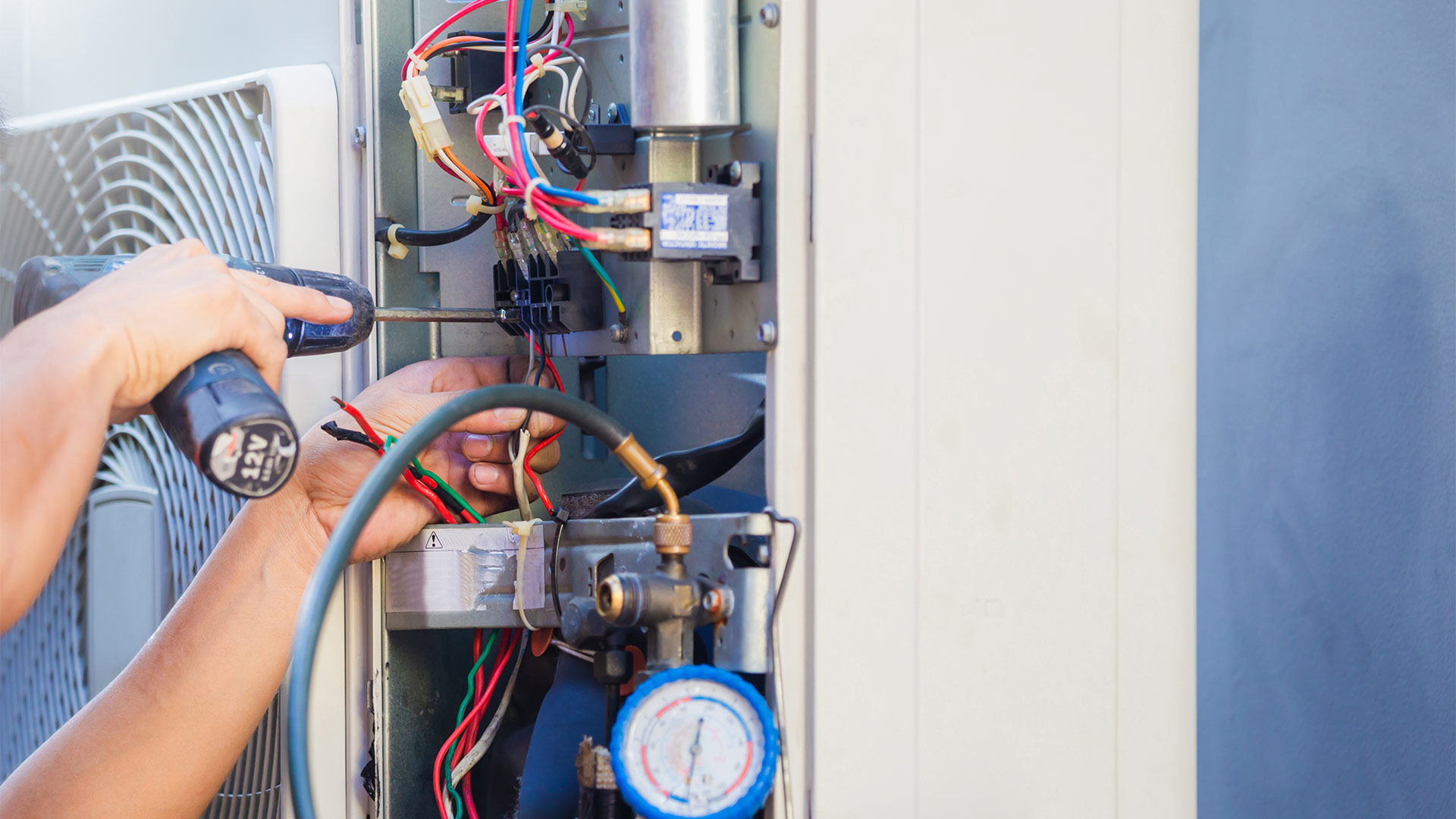 hvac technician with drill close up repairing commercial units at building collinsville il