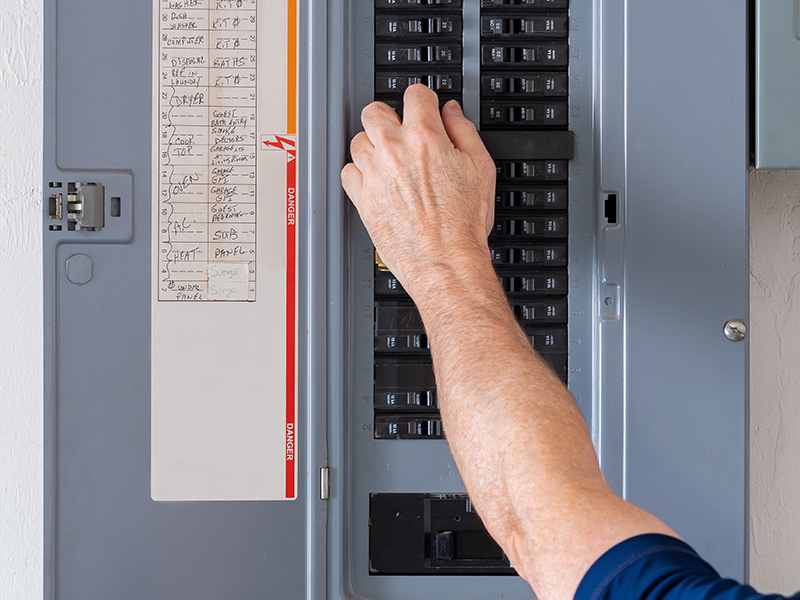 technician hands installing breakers replacement at circuit panel collinsville il